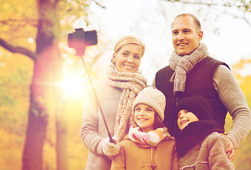 Image showing happy family with smartphone and monopod in park