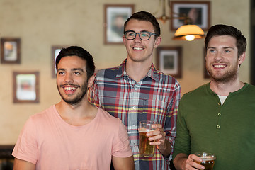 Image showing happy male friends drinking beer at bar or pub