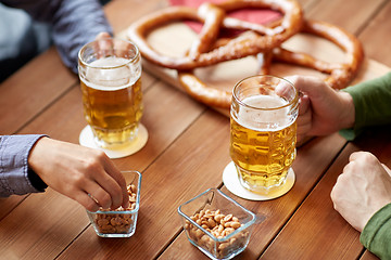 Image showing close up of hands with beer mugs at bar or pub