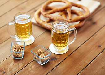 Image showing close up of beer, pretzels and peanuts on table