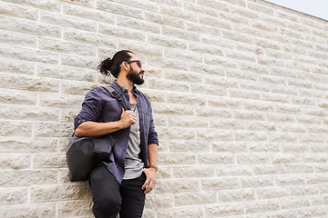 Image showing man with backpack standing at city street wall