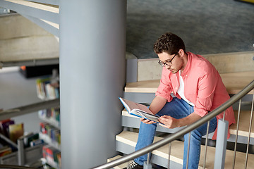 Image showing student boy or young man reading book at library