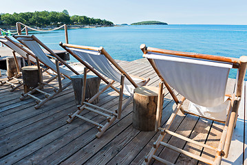 Image showing Wooden floor with chaise-longues and tables