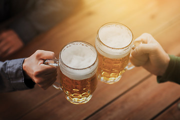 Image showing close up of hands with beer mugs at bar or pub