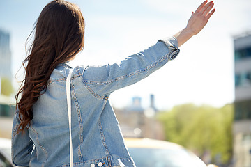 Image showing young woman or girl catching taxi on city street