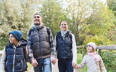 Image showing happy family with backpacks hiking in woods