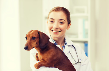 Image showing happy doctor with dog at vet clinic