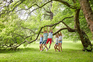 Image showing happy kids hanging on tree in summer park