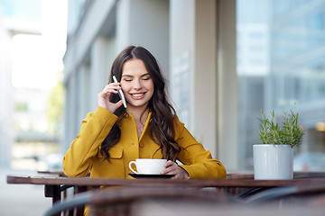 Image showing happy woman calling on smartphone at city cafe