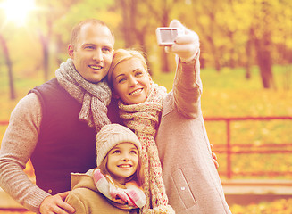 Image showing happy family with camera in autumn park