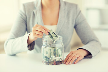 Image showing close up of woman hands and dollar money in jar