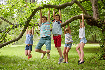 Image showing happy kids hanging on tree in summer park