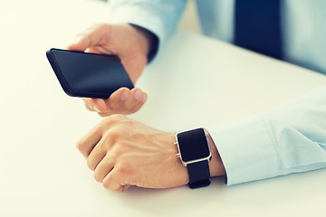 Image showing close up of hands with smart phone and watch