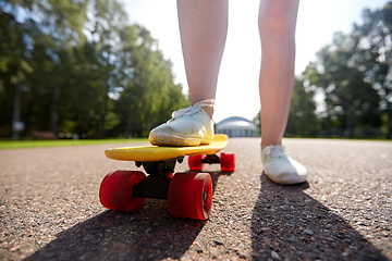 Image showing close up of female feet riding short skateboard