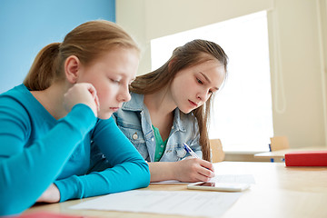 Image showing student girls with smartphone writing school test