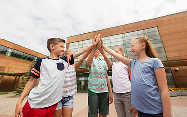 Image showing group of children making high five at school yard