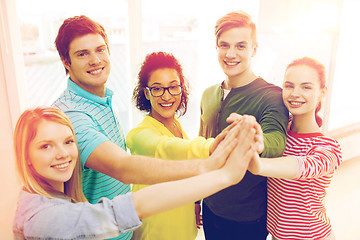 Image showing five smiling students giving high five at school