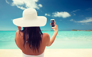 Image showing woman taking selfie with smartphone on beach