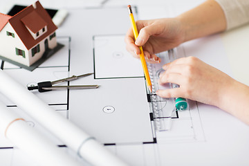 Image showing close up of hands with compass measuring blueprint