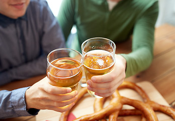 Image showing close up of hands clinking beer at bar or pub