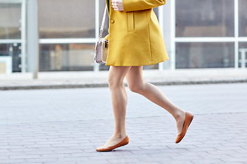 Image showing young woman legs running along on city street