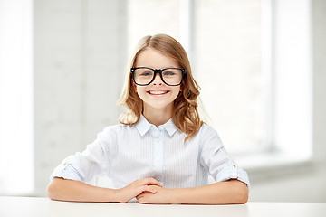 Image showing happy school girl in glasses sitting at table