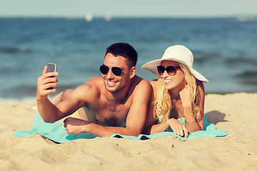 Image showing happy couple in swimwear walking on summer beach