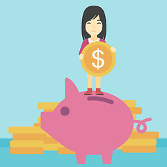 Image showing Business woman putting coin in piggy bank.