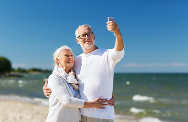 Image showing happy senior couple hugging on summer beach