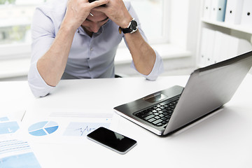 Image showing businessman with laptop and papers in office