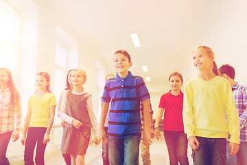 Image showing group of smiling school kids walking in corridor