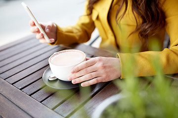 Image showing close up of woman texting on smartphone at cafe