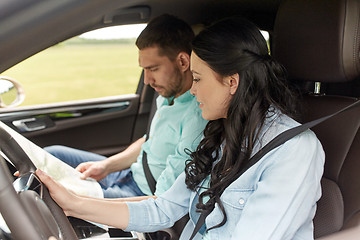 Image showing happy man and woman with road map driving in car