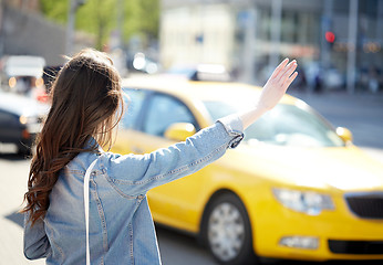 Image showing young woman or girl catching taxi on city street