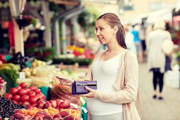 Image showing pregnant woman with wallet buying food at market