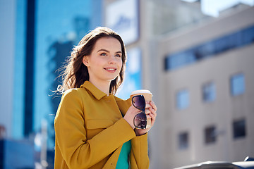 Image showing happy young woman drinking coffee on city street