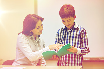 Image showing school boy with notebook and teacher in classroom