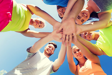 Image showing group of happy friends with hands on top outdoors