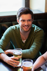 Image showing happy friends drinking beer at bar or pub