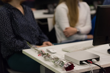 Image showing rose flower on famale students table on class