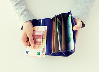 Image showing close up of woman hands with wallet and euro money