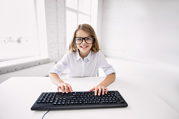 Image showing smiling girl in glasses with keyboard at school