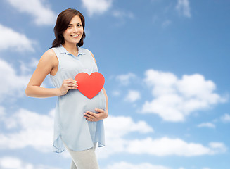 Image showing happy pregnant woman with red heart touching belly