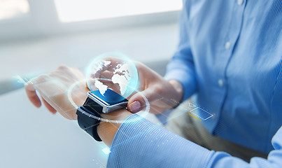 Image showing close up of hands and globe hologram on smartwatch