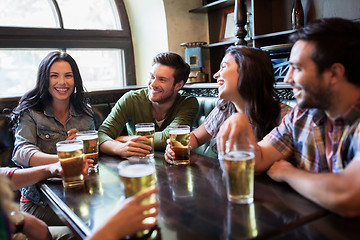 Image showing happy friends drinking beer at bar or pub