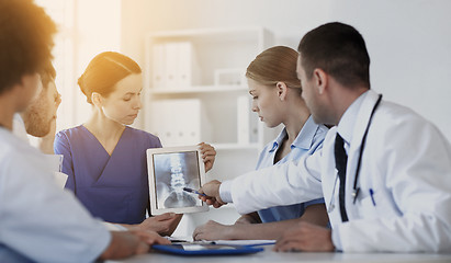 Image showing group of doctors with x-ray on tablet pc at clinic