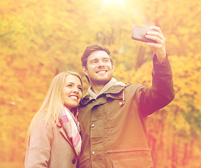 Image showing smiling couple hugging in autumn park