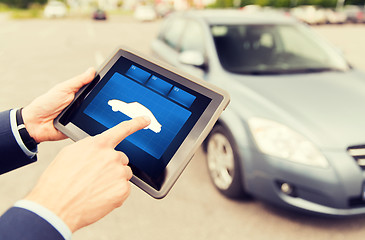 Image showing close up of male hands with car icon on tablet pc