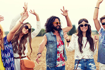 Image showing happy young hippie friends dancing on cereal field