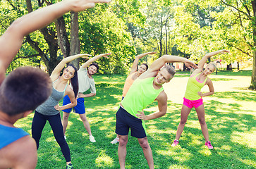 Image showing group of friends or sportsmen exercising outdoors